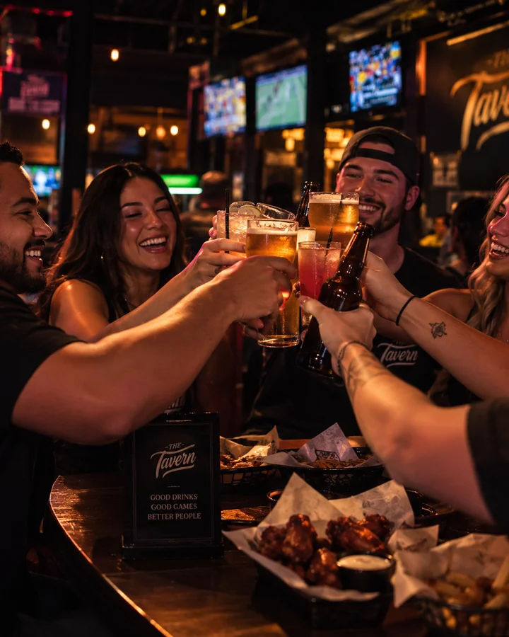 Friends raising drinks together at The Tavern